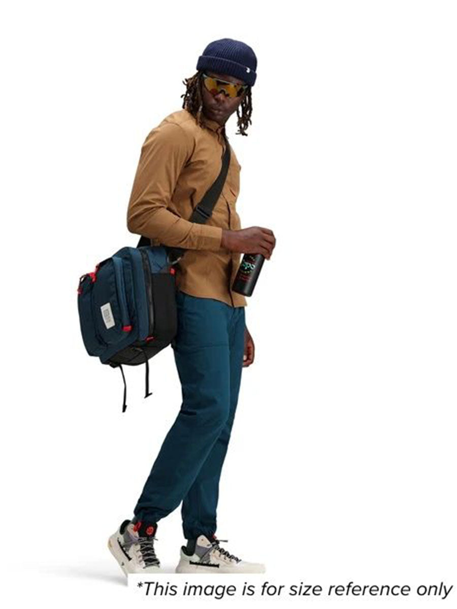 A man showcasing a bag for size reference.