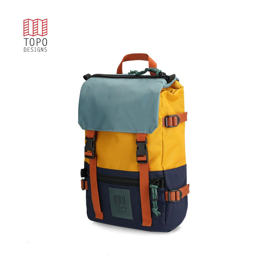 A Rover Pack Mini Backpack with top handle, featuring a combination of blue, yellow, and navy colors with orange straps and buckles.