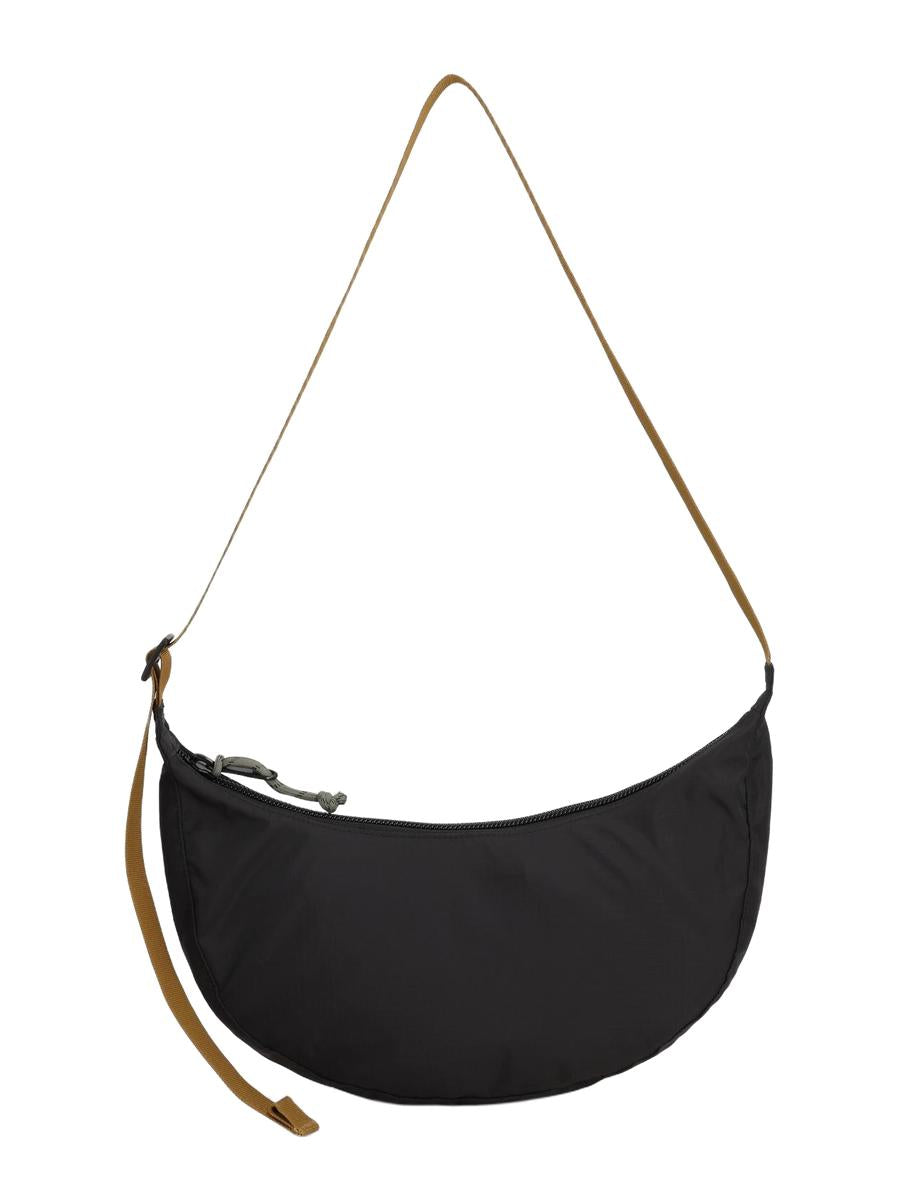 A backside view of a black Moonlight Crossbody Bag with an adjustable shoulder strap and a front zippered pocket.