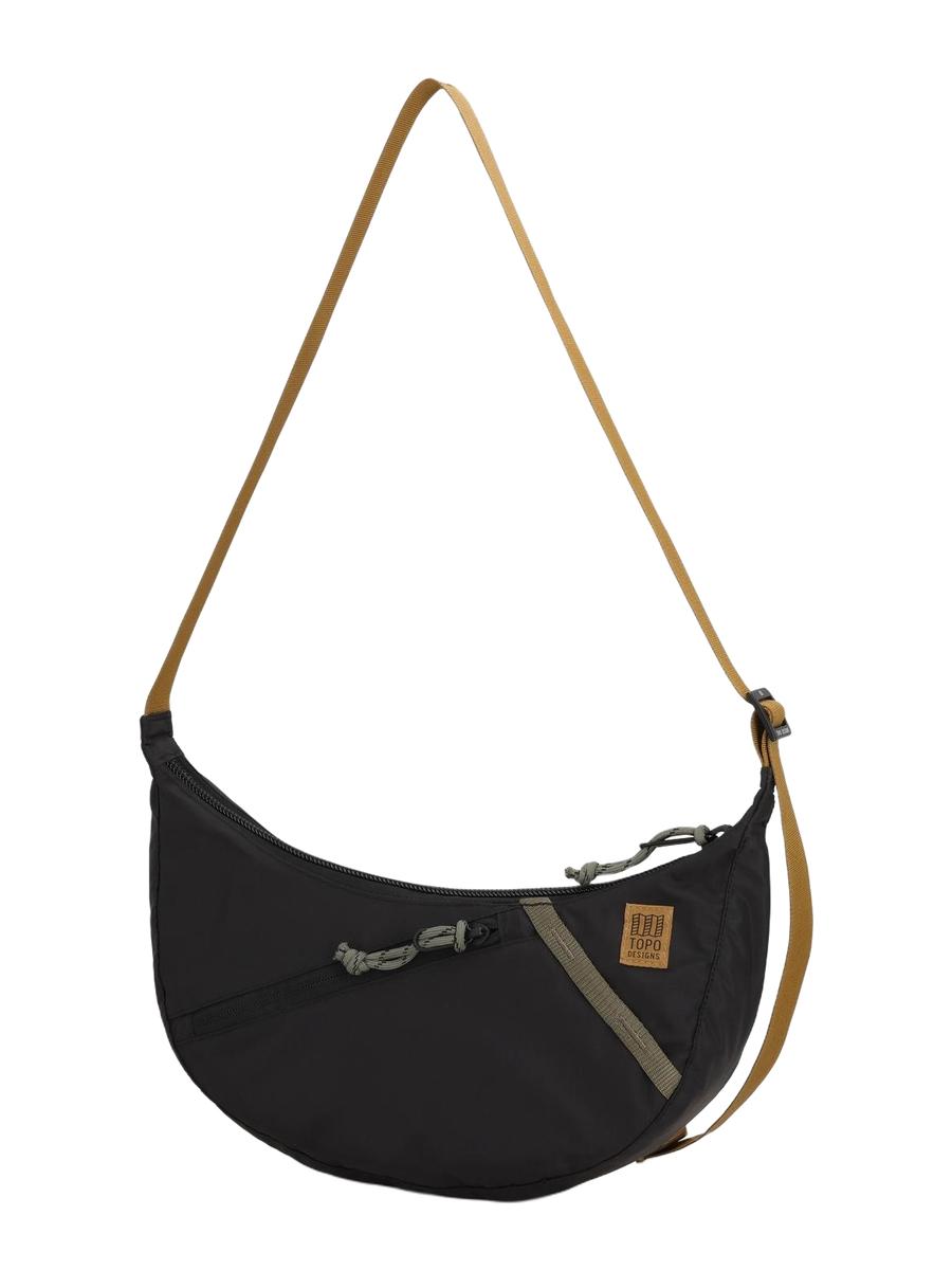 A black Moonlight Crossbody Bag with an adjustable shoulder strap and a front zippered pocket.