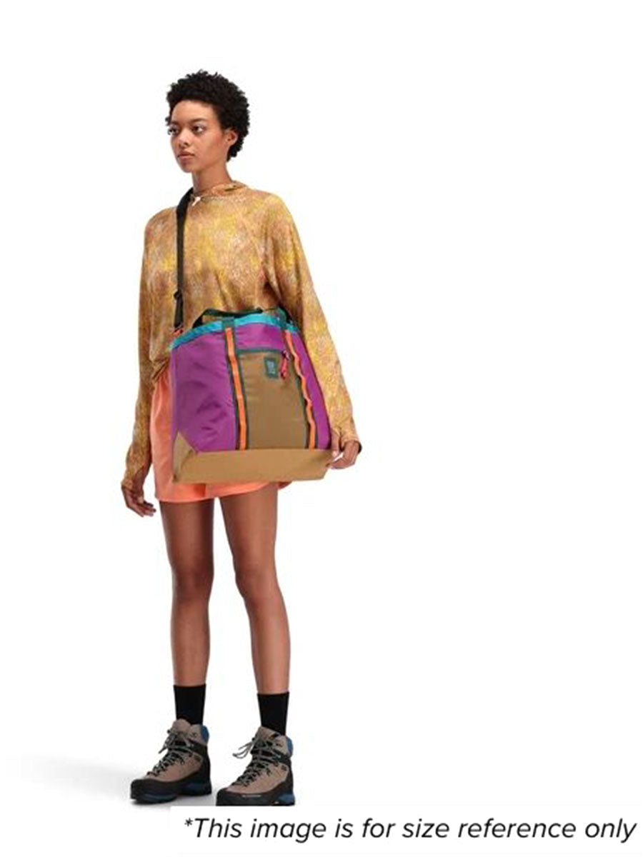 A woman showcasing a Mountain Utility Tote Shoulder bag for size reference.