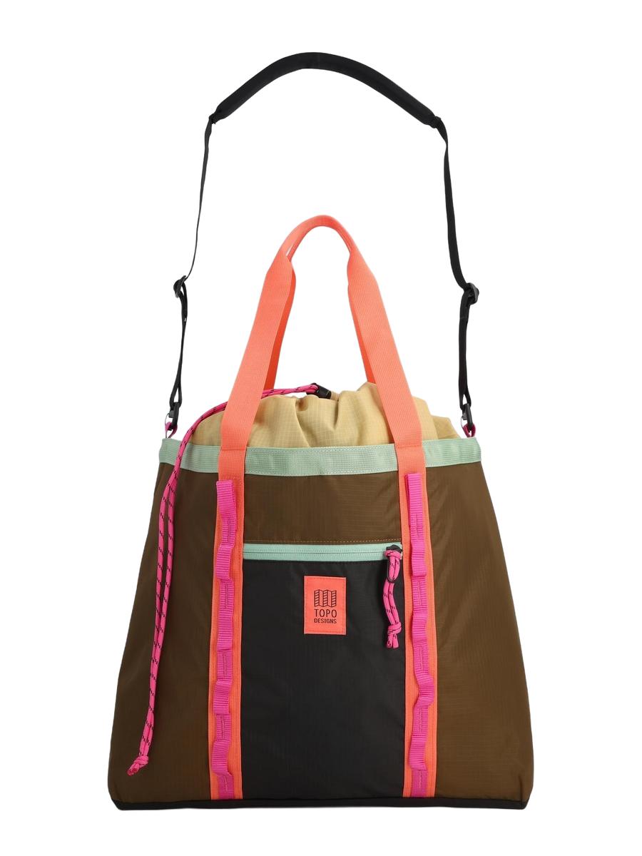 A multicolored Mountain Utility Tote Shoulder Bag with a brown base, and pinkish accents and a black adjustable padded shoulder strap.