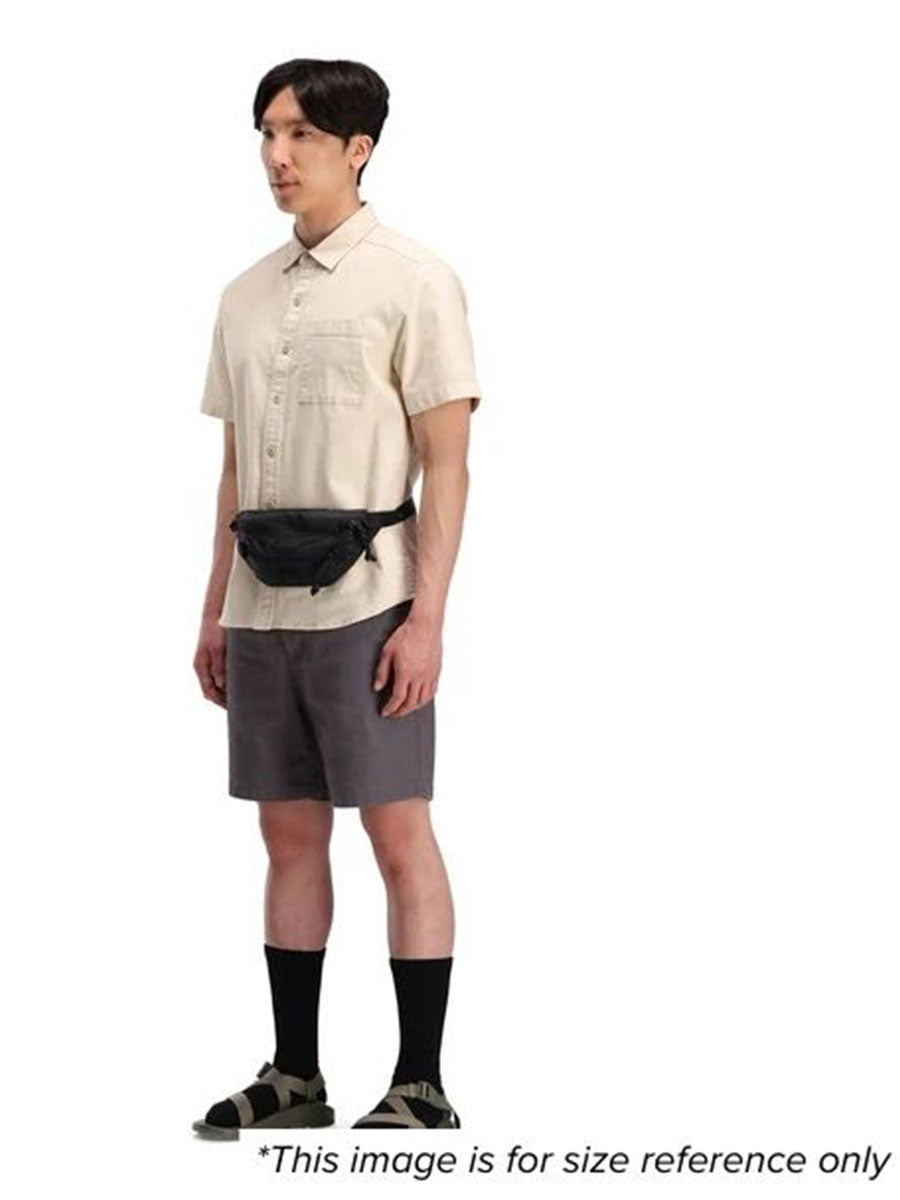 A man showcasing a black waist pack for size reference.