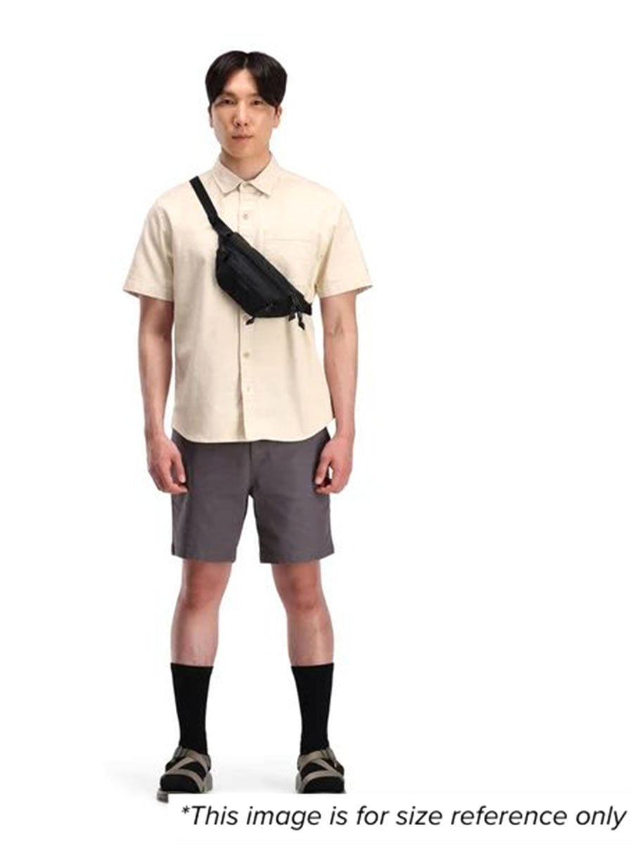 A man showcasing a waist pack wearing it on his shoulder for size reference.